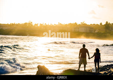 Près de ocean couple holding hands on beach Banque D'Images