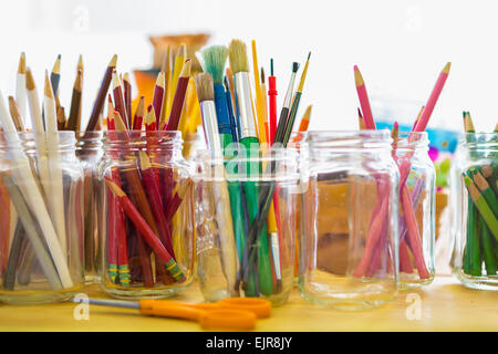 Close up de pots de crayons de couleurs et pinceaux Banque D'Images