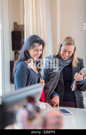 Les propriétaires de petites entreprises using digital tablet in store Banque D'Images