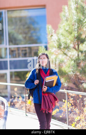 Mixed Race student holding books sur le campus Banque D'Images