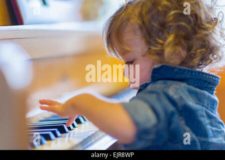 Caucasian baby boy playing piano Banque D'Images