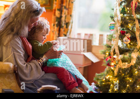 Grand-mère de race blanche et petit-fils de l'ouverture présente near Christmas Tree Banque D'Images