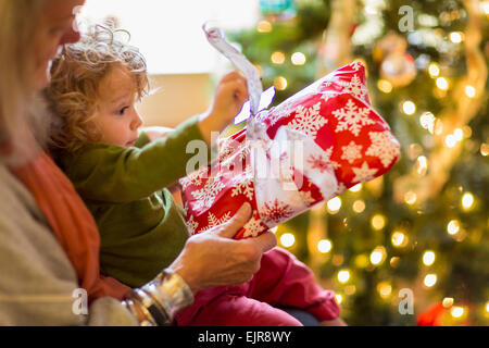 Grand-mère de race blanche et petit-fils de l'ouverture présente near Christmas Tree Banque D'Images