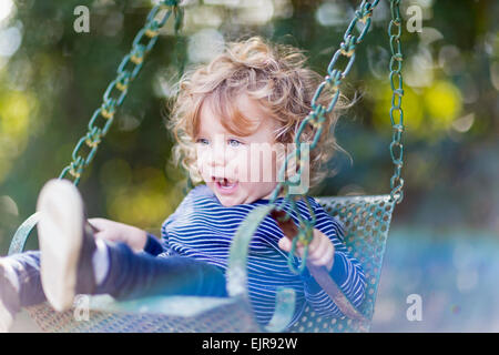 Caucasian baby boy sitting on swing Banque D'Images