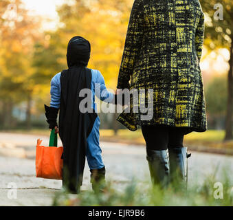 African American boy trick-or-treat avec mère sur Halloween Banque D'Images