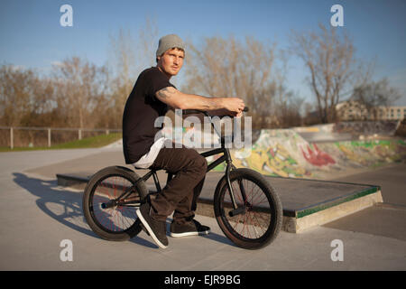 Caucasian man riding bicycle BMX au skate park Banque D'Images