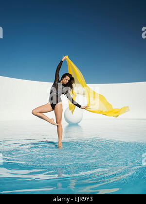 Caucasian woman dancing avec un tissu sur la surface de l'eau Banque D'Images