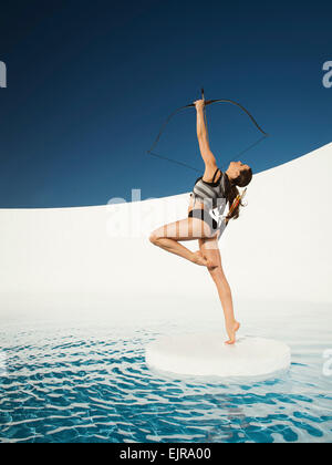 Caucasian woman visant l'arc et de la flèche sur la banquise Banque D'Images