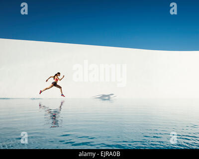 Caucasian woman running on water surface Banque D'Images