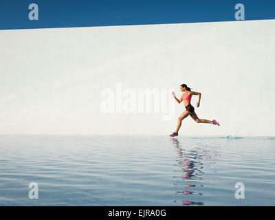 Caucasian woman running on water surface Banque D'Images