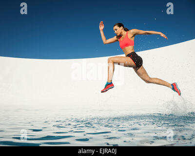 Caucasian woman running on water surface Banque D'Images