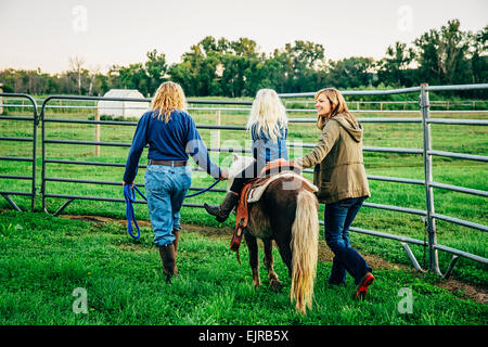 Trois générations de femmes de race blanche balade cheval miniature on farm Banque D'Images
