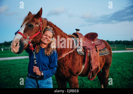 Caucasian woman smiling with horse ranch sur Banque D'Images