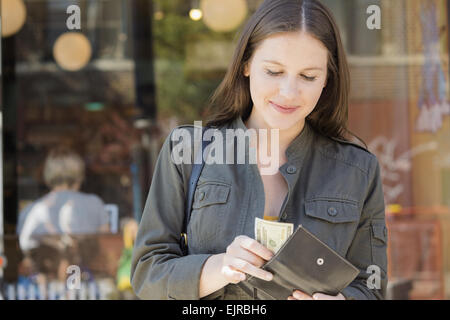 Caucasian woman counting money in wallet Banque D'Images