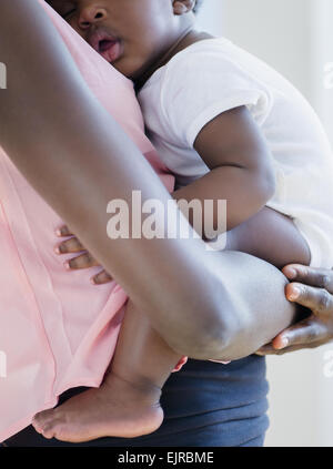 Black Mother holding sleeping fils