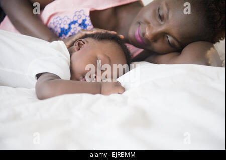 Mère fils noir admirant dormir sur le lit Banque D'Images