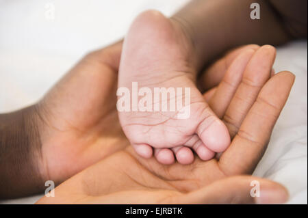 Close up of Black Mother holding Pied de bébé Banque D'Images