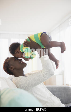 Mère noire jouer avec bébé garçon sur canapé Banque D'Images