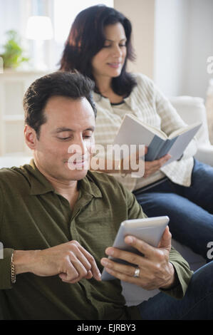 Couple reading in living room Banque D'Images