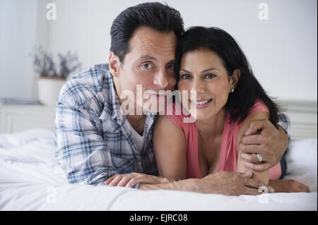 Close up of couple hugging on bed Banque D'Images