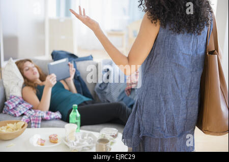 Femme frustrée de colocation paresseux using digital tablet on sofa Banque D'Images