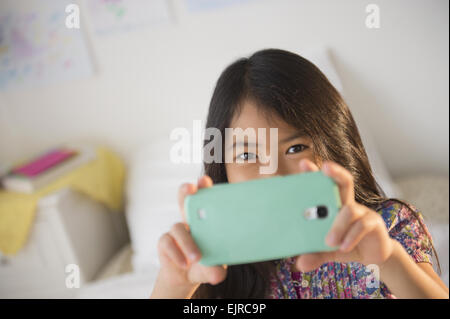 Smiling fille vietnamienne en tenant la photographie de téléphone cellulaire Banque D'Images