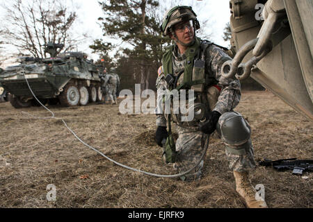 Le sergent de l'armée américaine. Daniwel Dana de la foudre Troop, 3e Escadron, 2e régiment de cavalerie à un remorquage Crochets câble à un véhicule blindé Stryker au cours d'un exercice de répétition de mission à l'inculcation de préparation interarmées multinationale Centre à Hohenfels, Allemagne, le 8 mars 2013. Le MRE est conçu pour assurer le déploiement d'unités sont capables de mener des opérations d'assistance des forces de sécurité afin de permettre aux Forces nationales de sécurité à assumer la responsabilité principale pour les opérations à l'appui de la gouvernance et de la sécurité et de vaincre l'insurrection au sein de la République islamique d'Afghanistan. La CPS. Tristan Bolden/pas revu Banque D'Images