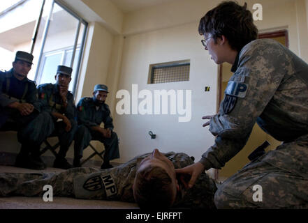 Le Sgt. Brenna McAllister du Destin, Floride, explique comment vérifier une impulsion à la lutte contre la police nationale afghane médecins affectés à l'Nazyan de police dans la province de Nangarhar, Afghanistan, le 10 mai. McAllister est un combat medic affecté à la 527e Compagnie de Police militaire. Banque D'Images