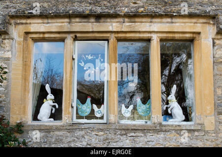 Les lapins de Pâques et ornements de poulet debout dans une fenêtre chalet dans la région des Cotswolds, en Angleterre Banque D'Images