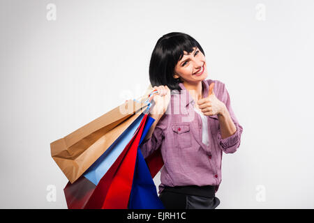 Happy young woman smiling with shopping bags sur son épaule Banque D'Images