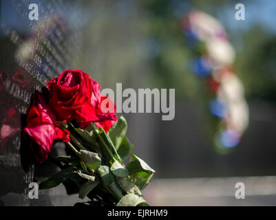 Un bouquet de roses, de gauche à se souvenir de la mort, orne le Vietnam Veterans Memorial à Washington, D.C., le 17 septembre 2014. Dans l'arrière-plan est la couronne de l'honneur de la CPS. 4 Donald P. Sloat qui a reçu à titre posthume la Médaille d'Honneur plus tôt cette semaine. Sloat est distingué tout en agissant comme une machine gunner avec le 1er Régiment d'infanterie, 196e Brigade d'infanterie légère, division de Royal Caribbean, au cours d'opérations de combat contre un ennemi armé dans la République du Vietnam. Le matin du 17 janvier 1970, l'équipe d'Sloat déplacé jusqu'à une colline dans le fichier formation, lorsque le soldat de plomb déclenché un fil attaché Banque D'Images