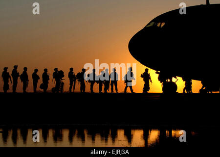 Le soleil se couche derrière un C-17 Globemaster III en tant que soldats à attendre en ligne à bord de l'aéronef, les renvoyer aux États-Unis 17 novembre at Joint Base Balad, de l'Iraq. C-17 peut transporter une charge utile maximale de 169 000 livres et peut atterrir sur de petits aérodromes. Le C-17 est déployé à partir de la 437e Escadre de transport aérien au Charleston Air Force Base, L.C. (U.S. Air Force photo/Tech. Le Sgt. Erik Gudmundson Banque D'Images