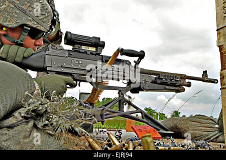 Douilles en laiton de munitions jonchent le sol que la CPS. Scott Stephenson, 148e Bataillon d'infanterie, la Garde nationale de l'Ohio, se qualifie avec le 240B machine gun au Camp Perry Centre de formation militaire conjointe à Port Clinton, Ohio, le 2 juin 2013. Photo de l'armée par le sergent. Sean Mathis Banque D'Images