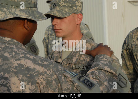 U.S. Army Engineer Cpl. Kyle Morris, droite, affecté à la 46e bataillon du génie, reçoit un certificat de mérite pour son travail pour aider à construire des installations de soutien à la sécurité commune, Zafaraniyah, l'Iraq, le 27 mars 2009. Banque D'Images