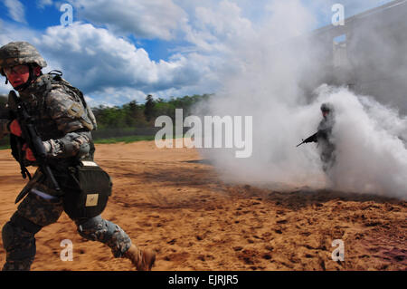 Le Lieutenant-colonel de l'armée américaine Anthony Digiacomo émerge d'un nuage de fumée tout en offrant le feu pour couvrir simulé de la CPS. Sean White au cours de la formation sur les opérations militaires en territoire urbain parcours sur Camp Grayling, Michigan, le 10 juin 2008. Les soldats participent à la Garde nationale Banque D'Images