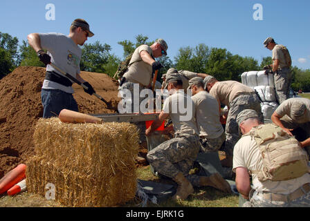 Des soldats américains affectés au 1er bataillon du 168e Régiment d'infanterie, la Garde nationale de l'Armée de l'Iowa remplir des sacs de sable de fortune à une station de remplissage-à Burlington, Iowa, le 17 juin 2008, pour les équipes qui travaillent à renforcer une digue protégeant plus de 100 maisons et 50 000 hectares de cultures à partir de l'augmentation des crues du fleuve Mississippi. L'Iowa aviateurs et soldats de la Garde nationale ont été activés pour travailler avec l'état et les organismes locaux d'assurer la sécurité et d'aider à récupérer les zones endommagées par des inondations généralisées. Le sergent-chef. Bill Wiseman Banque D'Images