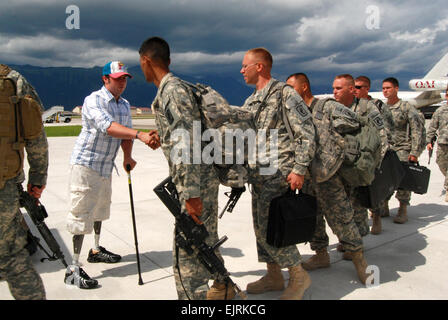 La CPS. Jesse A. Murphree, destinés Company, 2e bataillon du 503e Régiment d'infanterie, Airborne, accueille son 173e Airborne Brigade Combat Team camarades revenant d'un déploiement en Afghanistan, sur la ligne de vol à la base aérienne d'Aviano, en Italie, le 22 juillet. Murphree a perdu ses jambes dans un dispositif explosif attaque dans la vallée de Korengal, près de Ali Abad, Afghanistan, le 27 décembre 2007 et a été en traitement au Walter Reed Army Medical Center. Banque D'Images