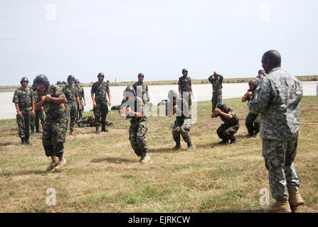 Le Sgt. 1ère classe de la 5ème Elie Acklin droit de l'entreprise Quartier-maître roumain par des guides de parachutistes pré-jump à la formation Joint Task Force-East sur la base aérienne de Mihail Kogalniceanu, la Roumanie, le 15 juillet. Le major Jennifer Johnson voir : /-news/2008/07/24/11150-us-parachutistes-partager... /-News/2008/07/24/11150-us-parachutistes-partager-les-compétences-avec-roumains homologues-/ Banque D'Images