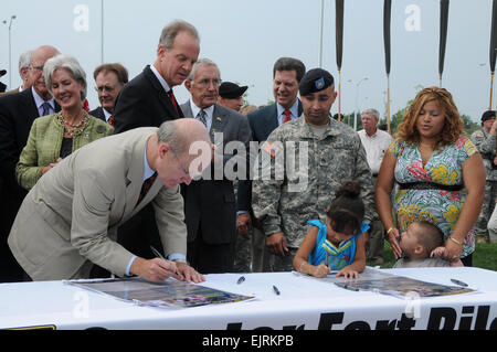 Secrétaire de l'Armée Pete Geren et la fille de sergent. Jose et Elizabeth Vera signer leur nom à une plus grande communauté de Fort Riley alliances pendant la cérémonie d'alliance communautaire de l'armée le 20 août à Fort Riley tandis que ses parents et son frère. Banque D'Images