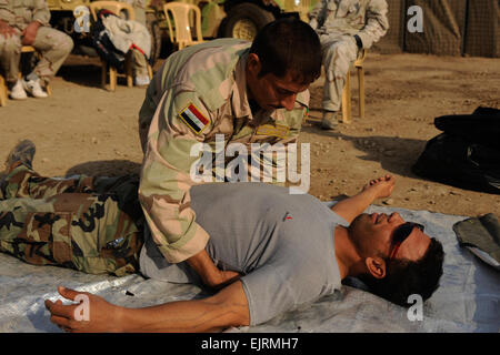 Un soldat irakien à partir de la 8e Division, l'armée iraquienne, vérifie son autre soldat de sang au cours de la formation médicale de l'armée américaine avec des soldats des forces spéciales, sur Camp Diwaniya, l'Iraq, le 1 décembre 2008. Des soldats irakiens sont formés par des soldats américains afin qu'ils soient prêts à assurer la sécurité de leur pays. Eric Harris Senior Airman Banque D'Images