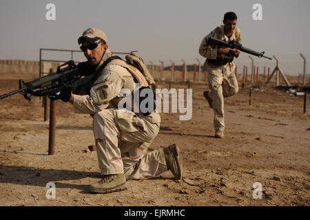 Un soldat irakien à partir de la 8e Division, l'armée iraquienne, fournit la sécurité tandis que son autre soldat se déplace à travers un obstacle vers une victime simulée au cours de formation médicale avec l'armée américaine, les soldats des Forces spéciales sur le Camp Diwaniya, l'Iraq, le 1 décembre 2008. Les soldats ont couru le parcours avant l'évaluation de leur victime afin de tester leurs performances dans des conditions stressantes. Eric Harris Senior Airman Banque D'Images