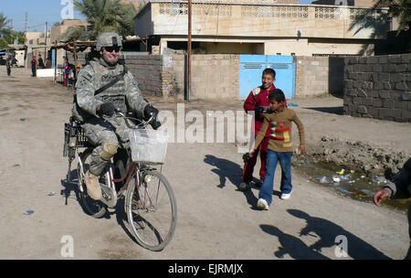 Le Sgt. 1re classe Waylon Petty, un natif de San Antonio, conduit une bicyclette à travers les rues de l'Karnabot Sud quartier de la province d'Abou Ghraib, à l'ouest de Bagdad, au cours d'une patrouille conjointe avec l'armée irakienne, le 8 décembre. La Division multinationale de Bagdad - Les soldats continuent d'accroître les relations avec les gens du pays tout en assurant la sécurité et le confort lors des patrouilles conjointes avec l'armée irakienne dans la province d'Abu Ghraib. La petite sert comme fantassin attribuée à la société B, 1er Bataillon, 21e Régiment d'infanterie, 2e "vrilles" Stryker Brigade Combat Team "Warrior", 25e Division d'infanterie. Banque D'Images