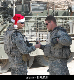 CAMP TAJI, Iraq - le colonel Todd McCaffrey gauche, natif de Hudson, Ohio, et commandant le 2 e Stryker Brigade Combat Team "Warrior", 25e Division d'infanterie, Division multinationale - Bagdad, souhaite de joyeuses fêtes et encourage un soldat affecté au 1er Bataillon, 21e Régiment d'infanterie, "vrilles", 2e à "SBCT Finir fort" lors de sa visite à la station commune de sécurité, Nassir Wa salam, l'ouest de Bagdad le 25 décembre. Le bouton "Terminer" Forte campagne exhorte les soldats à la lutte contre la complaisance Guerrier au cours de leurs deux derniers mois en Iraq. Le Major Al Hing, 2e SBCT PAO, 25 Inf. Div., DN-B Banque D'Images