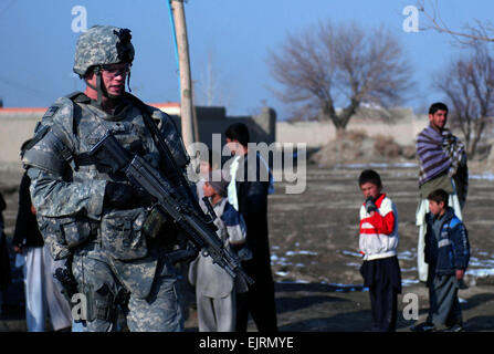 D'une patrouille à pied à travers une zone à Kaboul, Afghanistan, Rockford, Illinois, native de la CPS. Brett Devlin, les forces de sécurité de l'entreprise Delta, 33ème Infantry Brigade Combat Team, passe devant un groupe de sections locales. La patrouille, connue comme une patrouille de présence, vous permet de sections locales dans les villages de Kaboul savent que le 33e est dans leur région pour assurer le support. Également au cours d'une patrouille, les soldats parler avec les anciens du village d'obtenir des informations sur les récents événements dans le village. La CPS. Luke S. Austin, photojournaliste Banque D'Images