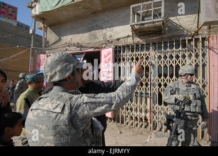 Un interprète irakien avec les soldats du 1er Bataillon, 18e Régiment d'infanterie, 2e Brigade lourde points à petite échelle qui est prévue pour recevoir un paiement de la part du gouvernement des États-Unis dans Shulah, l'Iraq, le 8 janvier. Le Gouvernement américain distribue des gains ou de l'argent aux petites entreprises pour l'amélioration et l'entretien de leurs boutiques. Banque D'Images