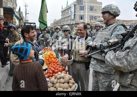 Le général Ray Odierno, commandant de la Force multinationale en Iraq - général, partage un rire avec une entreprise locale en Iraq Khalis, propriétaire, au cours d'une promenade sur le marché avec des soldats du 1er Stryker Brigade Combat Team, 25e Division d'infanterie, le 24 janvier. Banque D'Images