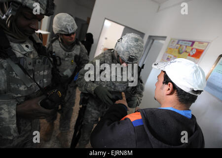 La CPS de l'armée américaine. Gregory étés de Ashburn Ga., affecté à la 2e Bataillon, 11e, 2e d'artillerie de Stryker Brigade Combat Team, 25e Division d'infanterie, Multi-National Division-Baghdad, utilise un scanner biométrique pour entrer un nouveau diplômé ingénieur en génie électrique dans le système de paye avant que l'ingénieur peut recevoir son premier chèque à une sous-station électrique dans la zone d'Abu Ghraib à Bagdad, l'Iraq, le 22 janvier. Banque D'Images