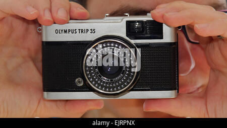 Une femme tenant le classique Olympus TRIP 35 Appareil photo compact Banque D'Images