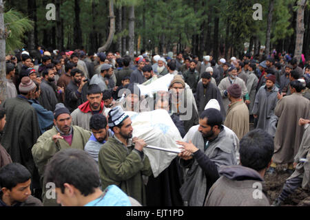 Srinagar, au Cachemire. 31 mars, 2015. Les villageois portent des corps morts dans un pied à Chadoora de la région du Cachemire indien le 31 mars 2015. Seize personnes sont décédées après un glissement de terrain provoqué par de fortes pluies ont enseveli plusieurs maisons. Credit : NISARGMEDIA/Alamy Live News Banque D'Images