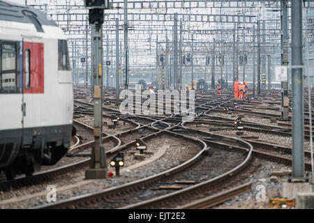 Les employés des chemins de fer et un train en laissant sur le champ de la voie de gare principale de Zurich, l'un des plus fréquenté d'Europe les gares ferroviaires. Banque D'Images